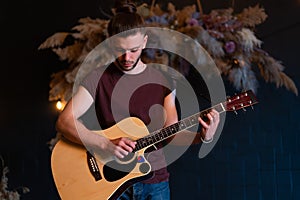 Male musician playing acoustic guitar. Guitarist plays classical guitar on stage in concert