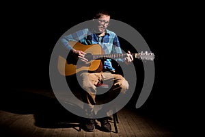 Male musician playing acoustic guitar and singing