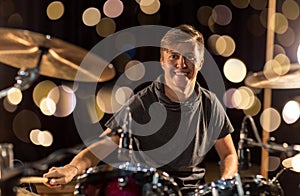Male musician playing drum kit at concert