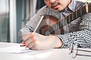 Male musician playing guitar and composing