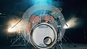 Male musician is rehearsing with a drum set in a studio