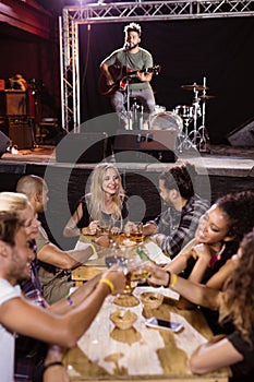 Male musician singing with fans sitting at table