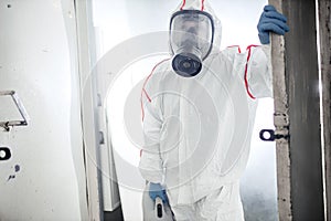 Male in an NBC personal protective equipment ppe suit cleaning isolated space