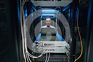 Male network administrator running software check of server equioment