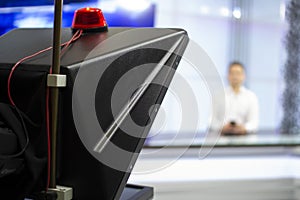 A male News anchor in a broadcast Studio reads text on a teleprompter. Camera in the TV Studio.
