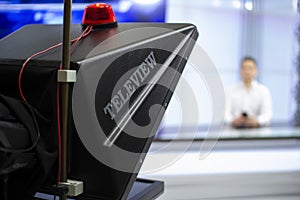 A male News anchor in a broadcast Studio reads text on a teleprompter. Camera in the TV Studio