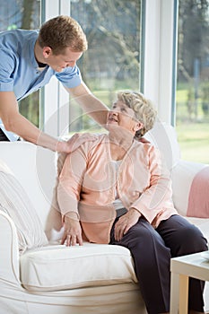 Male nurse assisting retired woman