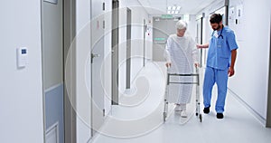 Male nurse assisting senior patient in using a walking frame