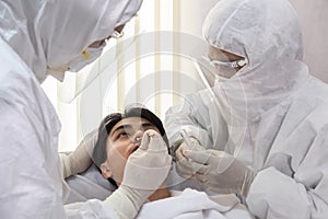 Male nurse and doctor wearing ppe suit and facemask perform Coronavirus COVID-19 PCR test. patient nasal NP and oral OP swab