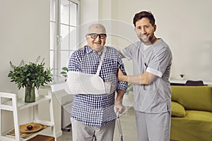 Male nurse helping elderly patient to recovery after injury at home