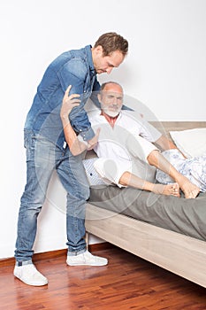 Male nurse helps man out of bed