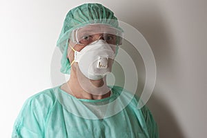 Male nurse, with plastic protective eyeglasses and respirator ffp1, cap, gown, gloves,  with  personal protective equipment to