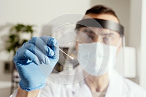 Male nurse about to take a nasopharyngeal culture photo