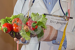 Male nutritionist holding fresh vegetables and fruit: healthy vegetarian diet concept. Portrait Of Male Dietician With Fresh Veget