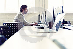 Male office worker looking at computer screen with data