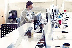Male office worker looking at computer screen with data