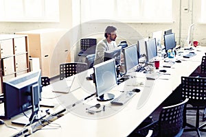 Male office worker looking at computer screen with data