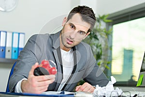 male office worker shock expression looking at alarm clock