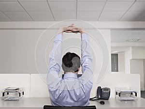 Male Office Worker Stretching At Desk