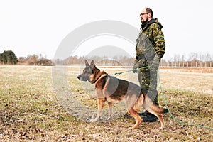 Male officer, military uniform and german shepherd on leash or dog guarding territory and outdoors. Soldier, pet with