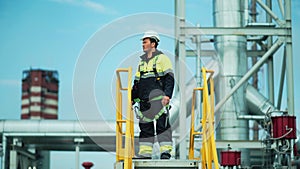 Male oil or gas factory worker going to observation deck tower for check industrial safety