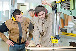 male operator using milling machine for cutting wood