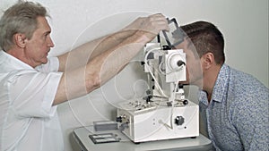 Male optician examining patient`s eye pressure