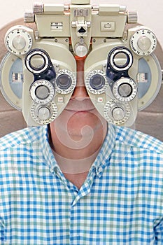 Male optometrist doing sight testing for male patient in clinic