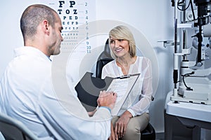 Male optometrist talking to female patient