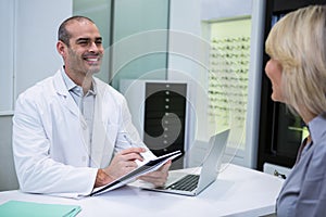 Male optometrist talking to female patient