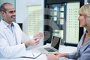 Male optometrist talking to female patient