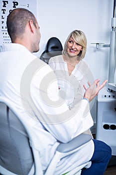 Male optometrist talking to female patient