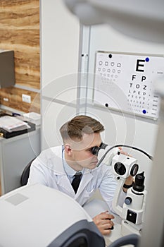 Male Optometrist Using Vision Test Equpment