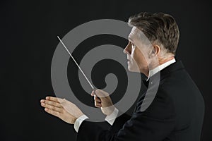 Male Orchestra Conductor Directing With His Baton photo