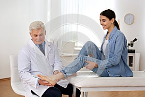 Male orthopedist fitting insole on patient`s foot