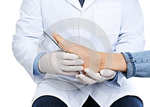 Male orthopedist fitting insole on patient`s foot against background, closeup