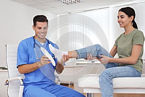 Male orthopedist fitting insole on patient`s foot