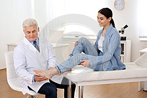 Male orthopedist fitting insole on patient`s foot photo
