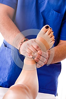 Male osteopath massaging the foot of a woman