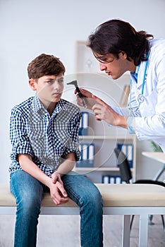 Male otolaryngologist examining boy`s ear
