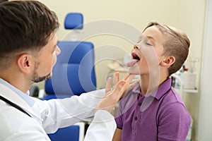 Male otolaryngologist examining little child