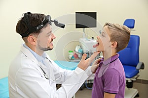 Male otolaryngologist examining little child