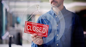 Male Owner Changing Closed Sign