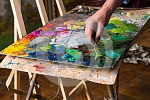 Male painter's hand working with paletteknife