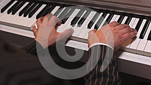 Male palms touching keyboards of piano while creating tune