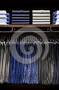 Male pants hanging on a clothes hanger inside a clothing store.