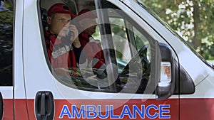 Male paramedic answering on patient call, professional ambulance crew, 911