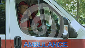 Male paramedic answering on patient's call, professional ambulance crew, 911