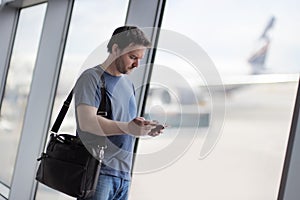 Male passenger at the airport with airplane on background