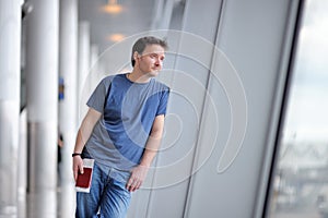 Male passenger holding passport and boarding pass at the airport